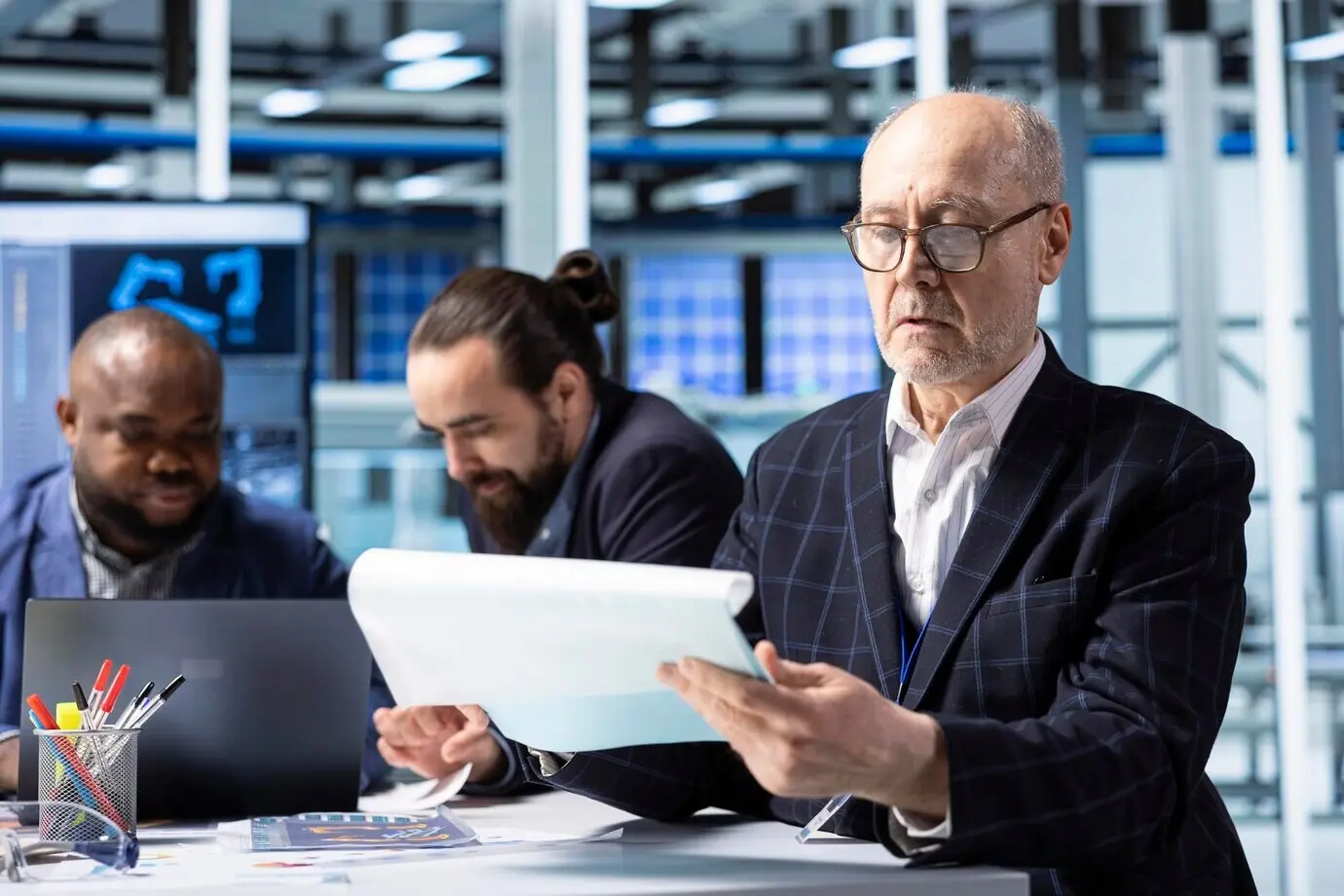 Accionista sénior de una planta industrial revisando documentos que analizan los ingresos.