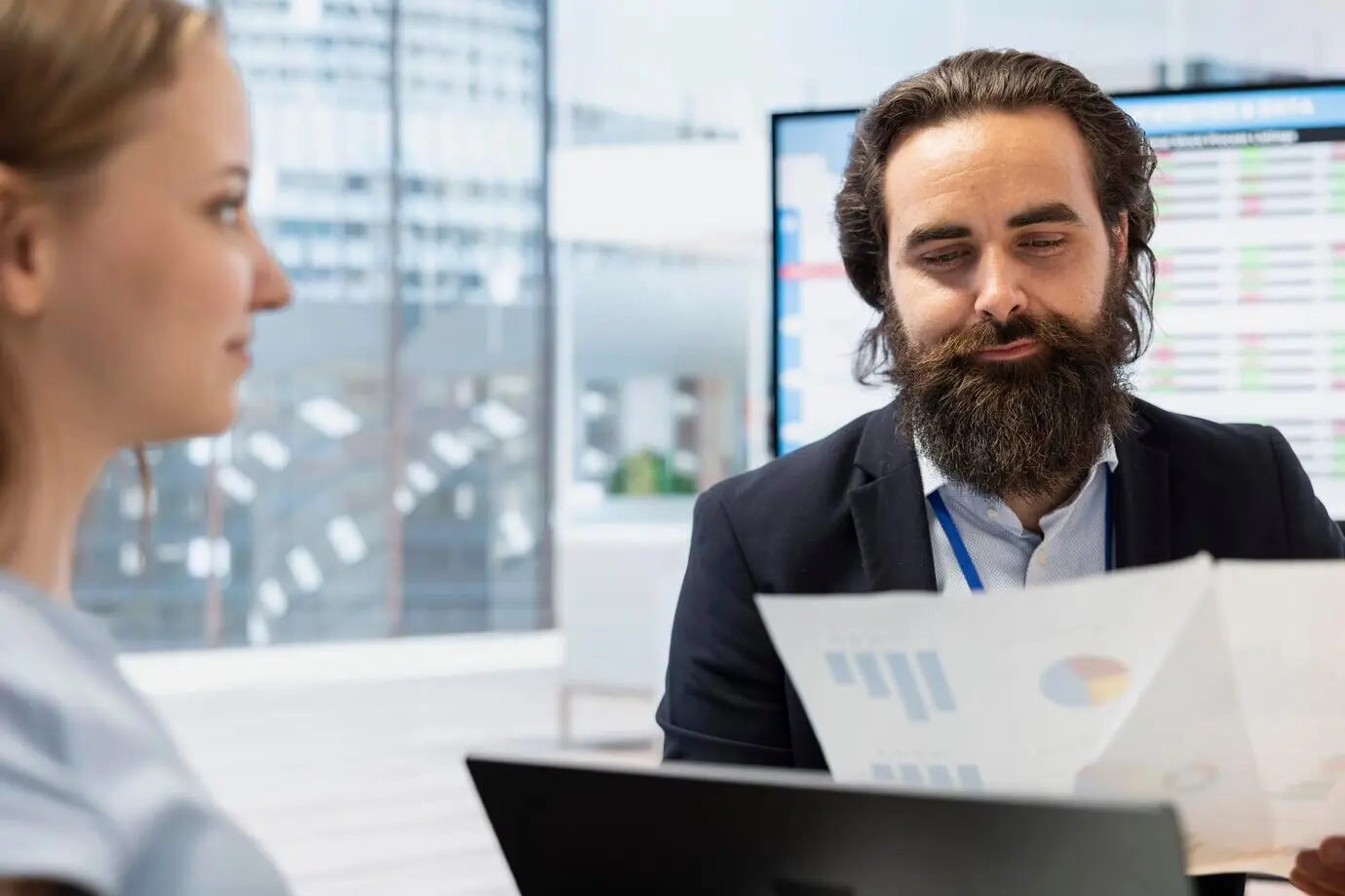 Asesor financiero guiando a un adulto joven en la compraventa de acciones.